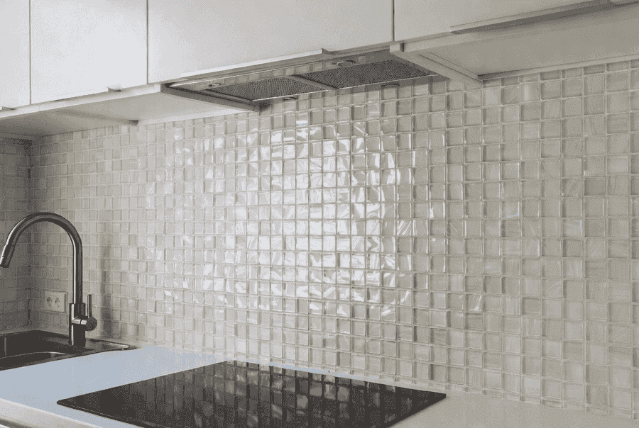 Glass mosaic tile kitchen backsplash reflecting light